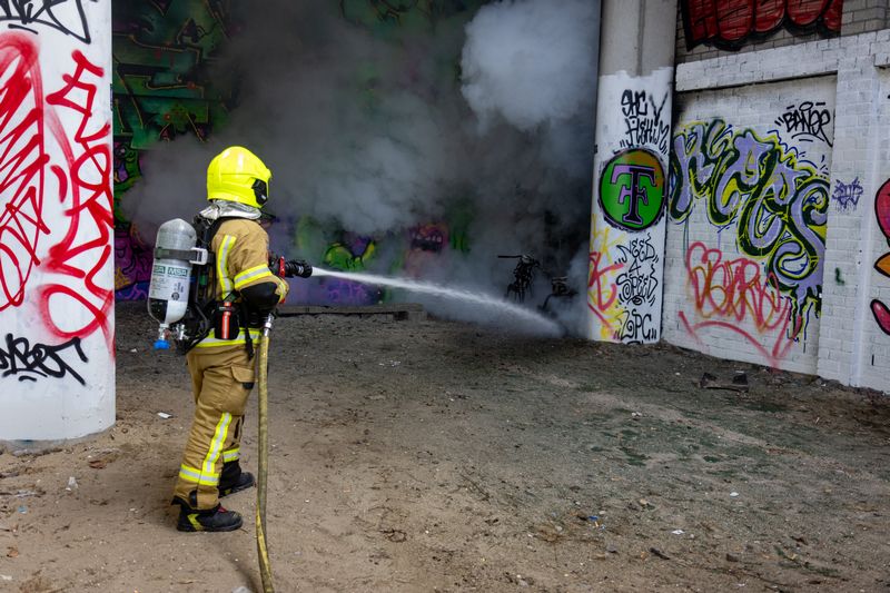 Rookontwikkeling over treinspoor door brandende scooter Rotterdam